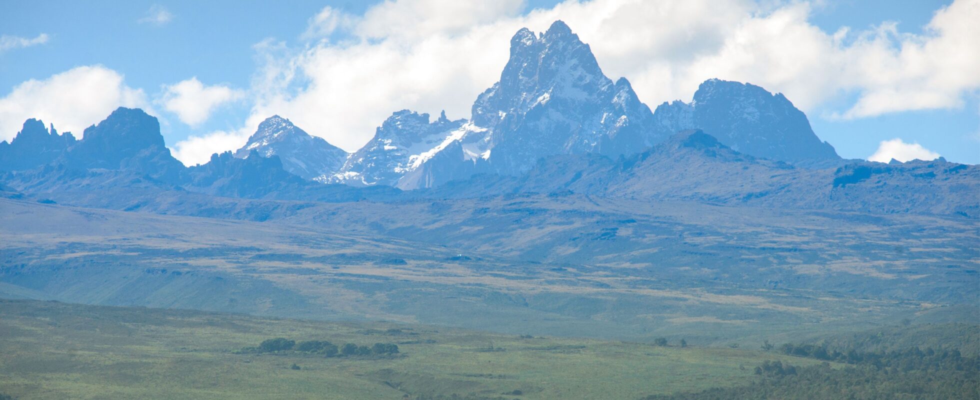 Mount Kenya from a distance with green landscape in front of it