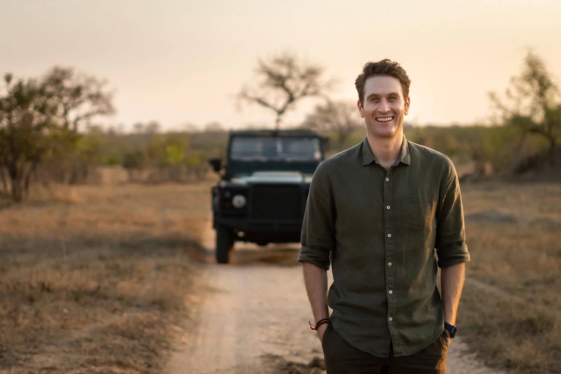 Personal safari guide standing beside a jeep in the African wilderness