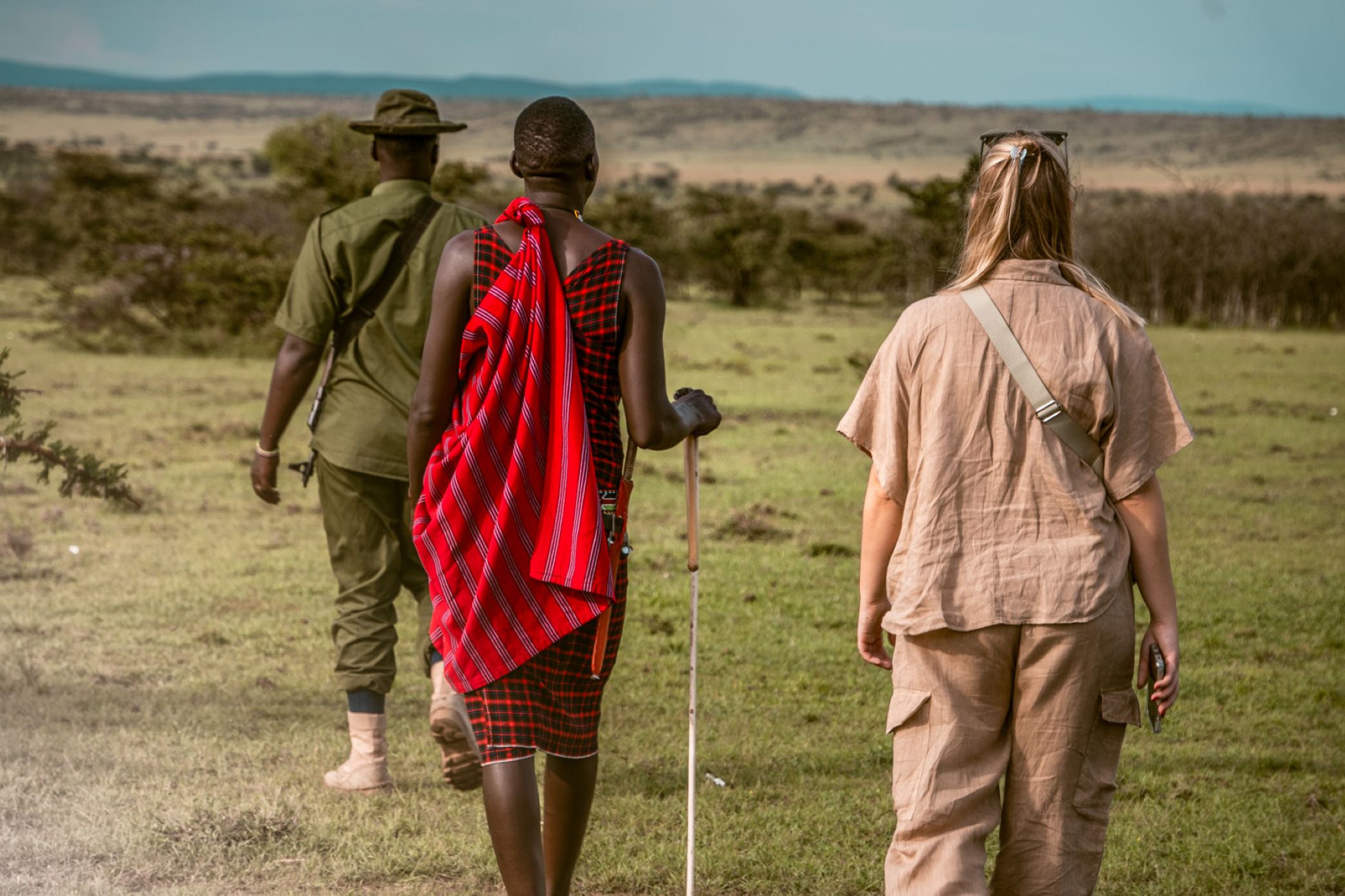 Guest on a guided walking safari with a Maasai guide and ranger in the Maasai Mara, Kenya.