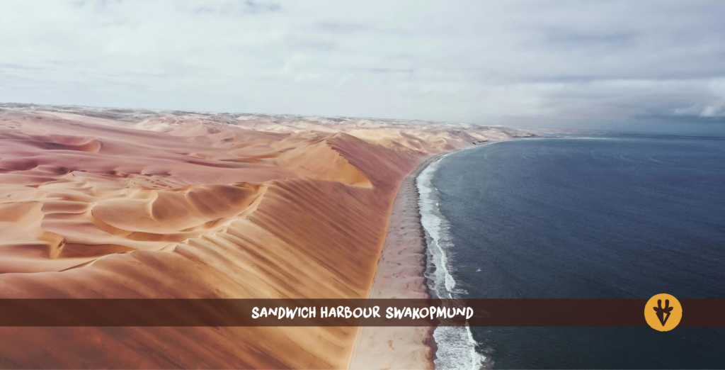Sand dunes and the ocean at Sandwich Harbour in Namibia